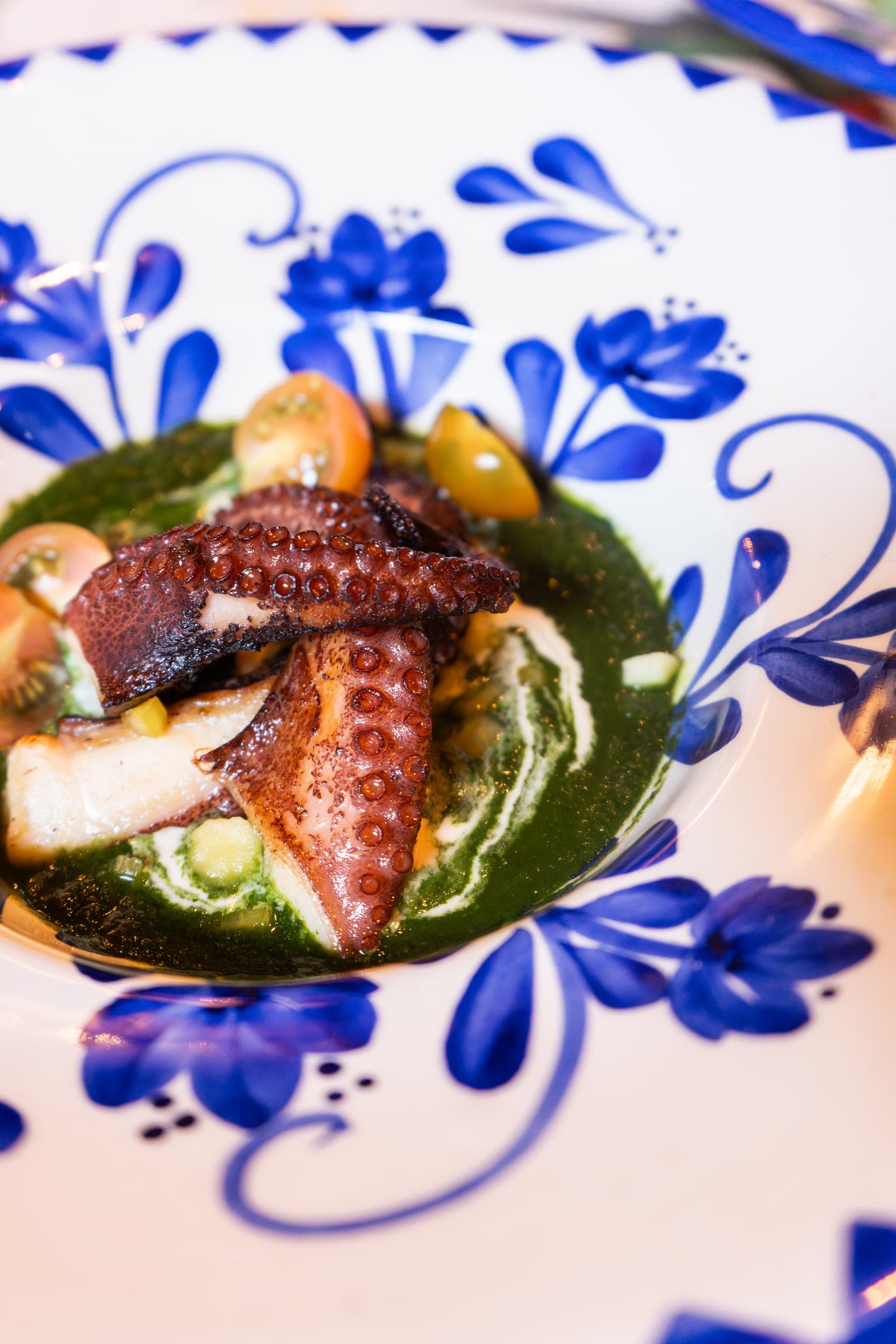 Pulpo sobre crema verde en vajilla de Talavera